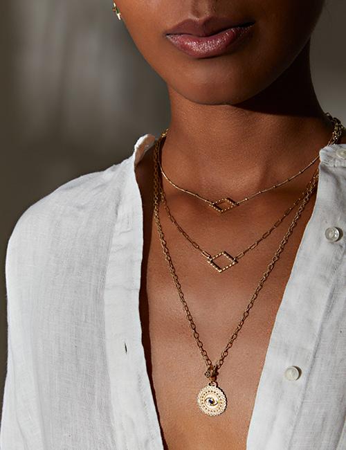 18 karat gold blue sapphire eveil eye pendant by spiritual fine jewelry designer Orly Marcel. Shown with gold chain necklaces